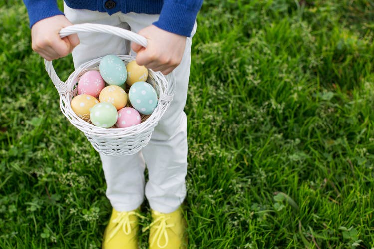 close-up view of eggs in easter basket being held by little boy after easter egg hunt