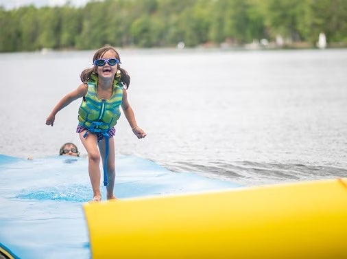 Girl riding the lilly pad on the lake