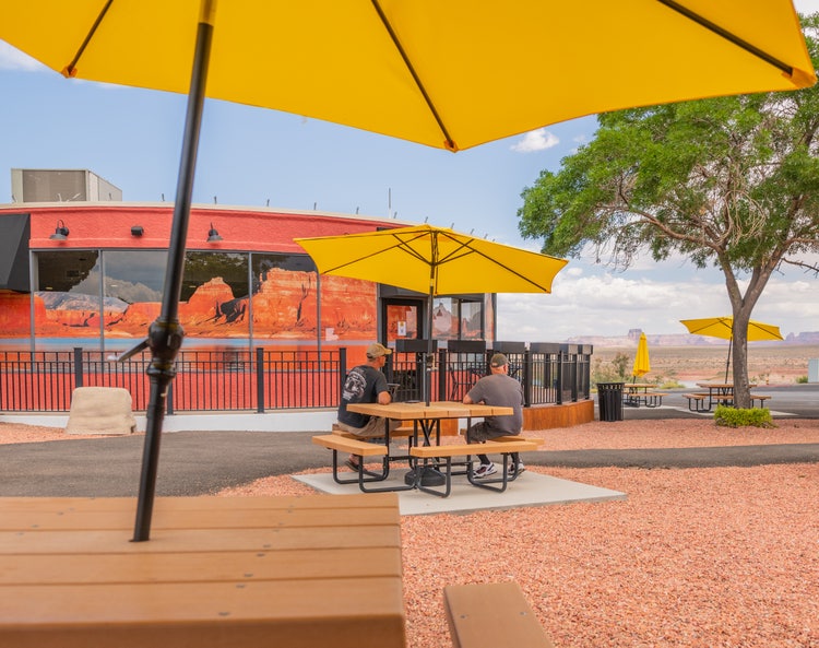 Outdoor view of Wahweap Pizza Co. with tables and yellow umbrellas