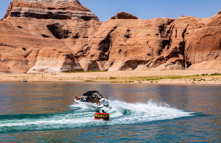 Power boat towing an inflatable water toy on Lake Powel