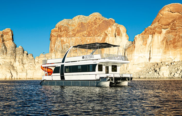 Houseboat on Lake Powell with dramatic cliffs in the background